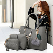 Gray 3-piece women’s embossed rose handbag set with shoulder bag and wallet displayed in a stylish lifestyle setting