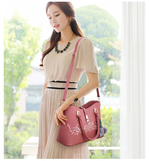 Pink 3-piece women’s embossed rose handbag set worn by a woman in a bright indoor lifestyle scene
