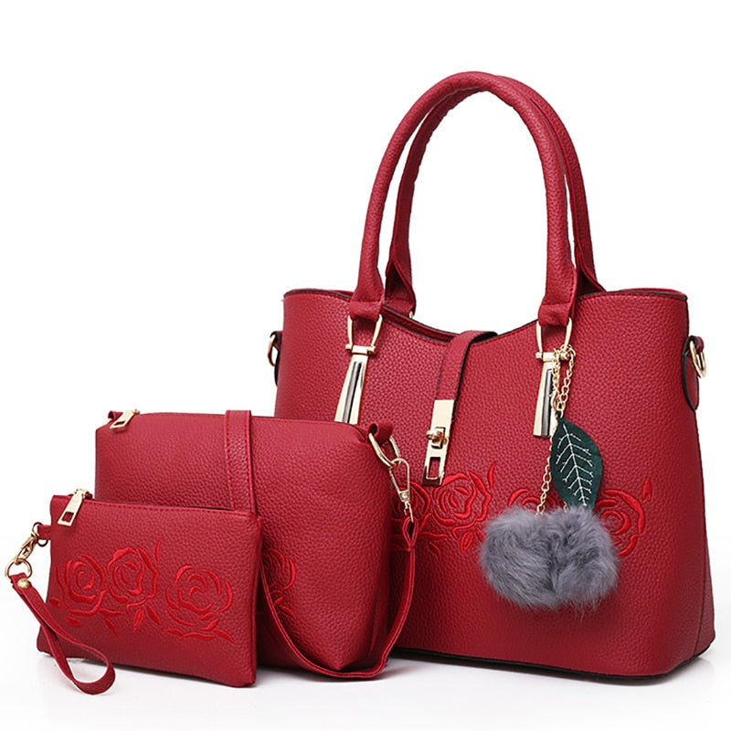 Red 3-piece women’s handbag set with embossed floral rose design and matching wallet