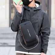 Men’s waterproof anti-theft sling bag with USB charging port, handheld close-up view.