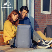 Lifestyle photo of a couple sitting outdoors with the light blue Kingsons backpack, showcasing its casual and modern style.