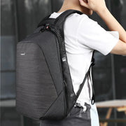 Man wearing a black anti-theft laptop backpack, showing ergonomic straps and slim profile suitable for daily commuting.