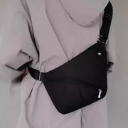 Back view of a person wearing a black tactical CCW sling bag with adjustable strap and slim profile.
