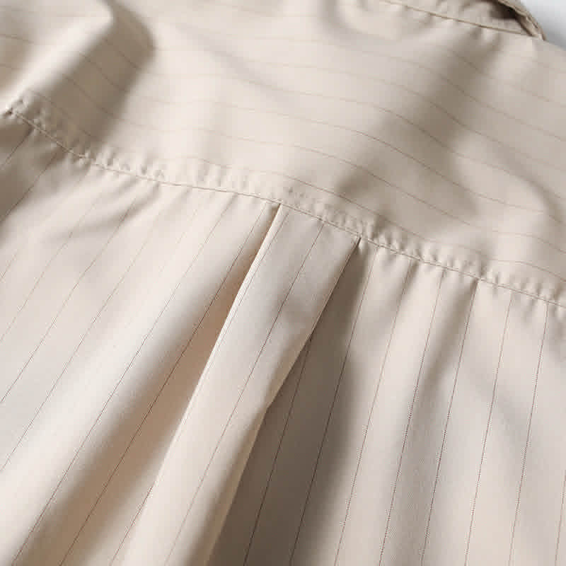Back pleat detail of beige retro loose fit short sleeve button-up shirt showing relaxed fit construction.
