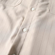 Premium button closure detail on beige retro loose fit short sleeve shirt.
