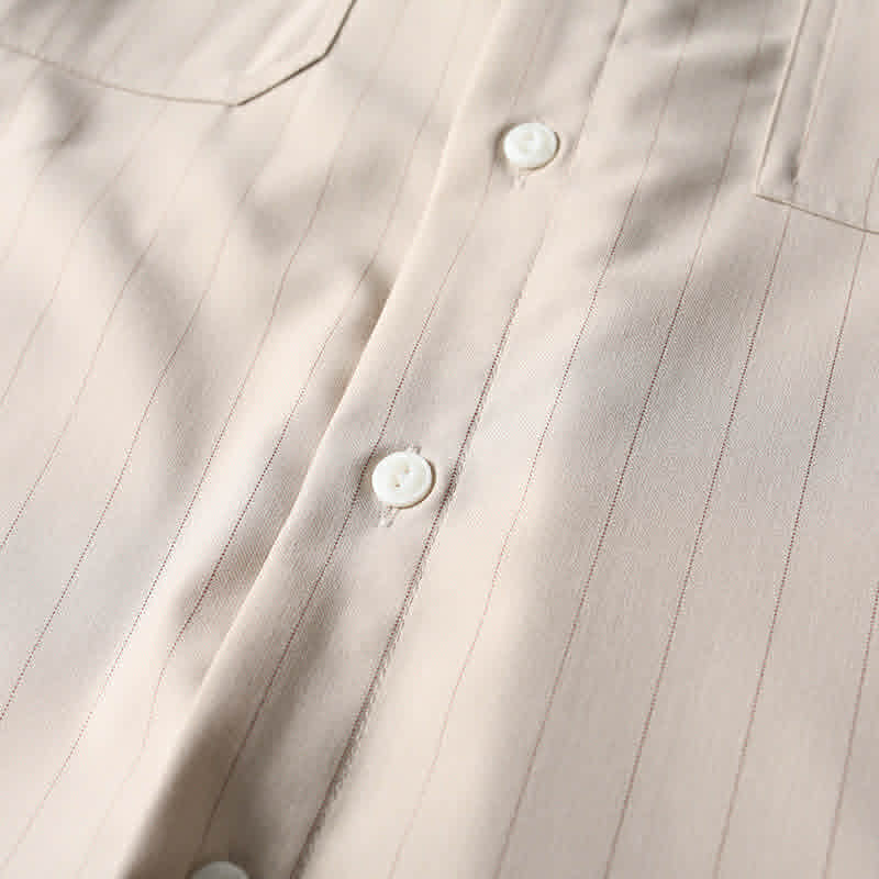 Premium button closure detail on beige retro loose fit short sleeve shirt.
