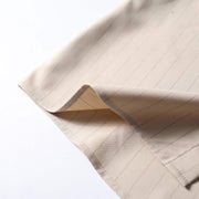 Lightweight breathable fabric detail of beige retro loose fit short sleeve button-up shirt.
