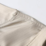 Shoulder seam craftsmanship detail on beige retro loose fit short sleeve shirt.

