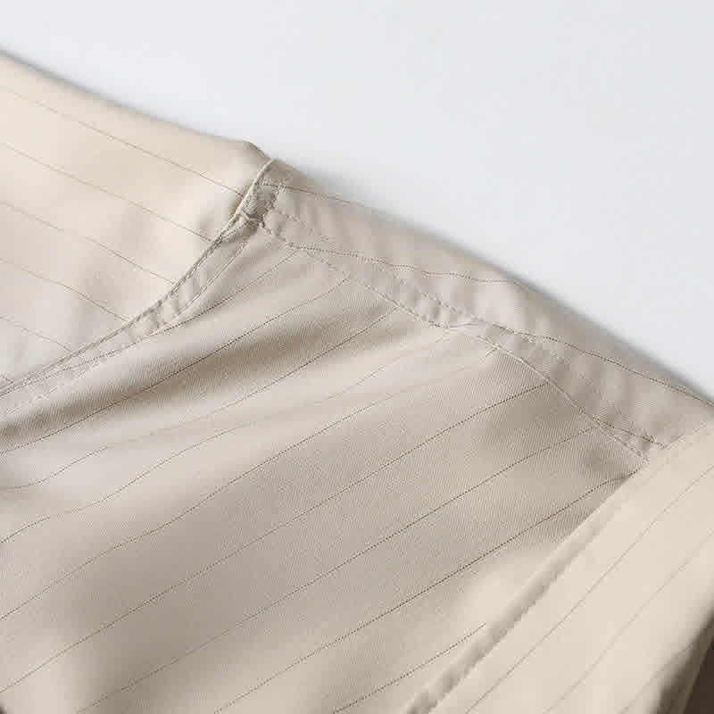 Shoulder seam craftsmanship detail on beige retro loose fit short sleeve shirt.
