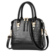 Black crocodile embossed handbag with top handles and adjustable shoulder strap
