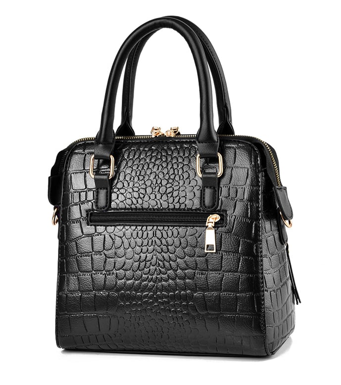 Back view of black crocodile embossed handbag featuring rear zip pocket and double top handles
