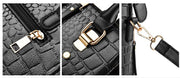 Close-up details of black crocodile handbag featuring gold zipper, buckle, and detachable shoulder strap hardware
