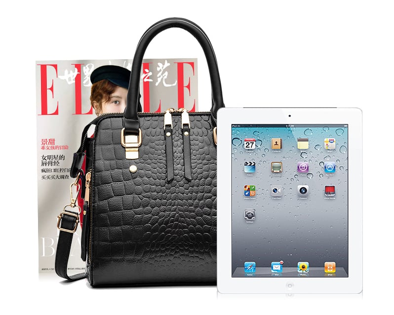 Black crocodile pattern handbag shown beside a tablet and magazine for size comparison
