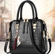 Black crocodile pattern handbag with gold accents and detachable shoulder strap
