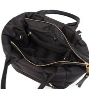 Interior compartment of a black winter puffer tote bag with zippered storage pockets.
