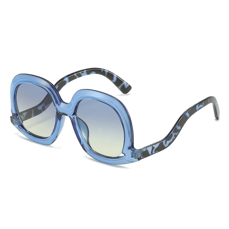 Blue leopard oversized oval sunglasses with blue yellow gradient lenses designed for trendy summer fashion looks.
