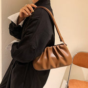 Auburn cloud soft shoulder bag worn with a black blazer, showcasing a chic minimalist shoulder bag style.
