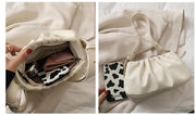 White cloud soft shoulder bag displaying spacious interior storage capacity with room for a phone, wallet, cosmetics, and daily essentials.
