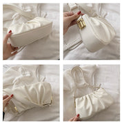 Multiple angle views of a white cloud soft shoulder bag featuring a structured base, pleated design, and adjustable shoulder strap.
