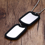 Stainless steel double dog tag necklace displayed on wooden surface with layered pendant style