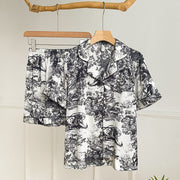 Elegant watercolor satin pajama set for women in black with short-sleeve button-up top and matching shorts.

