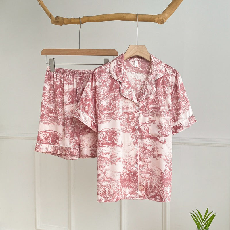 Elegant watercolor satin pajama set for women in pink with short-sleeve button-up top and matching shorts.
