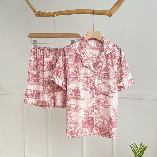 Elegant watercolor satin pajama set for women in pink with short-sleeve button-up top and matching shorts.
