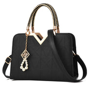 Elegant black women's handbag with gold top handle and shoulder strap
