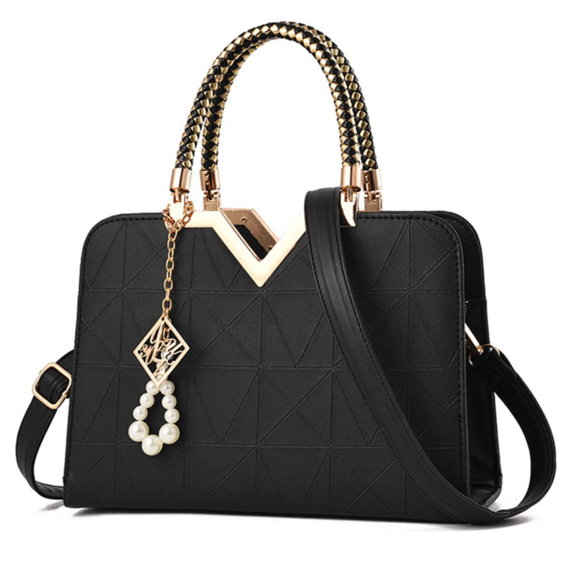 Elegant black women's handbag with gold top handle and shoulder strap
