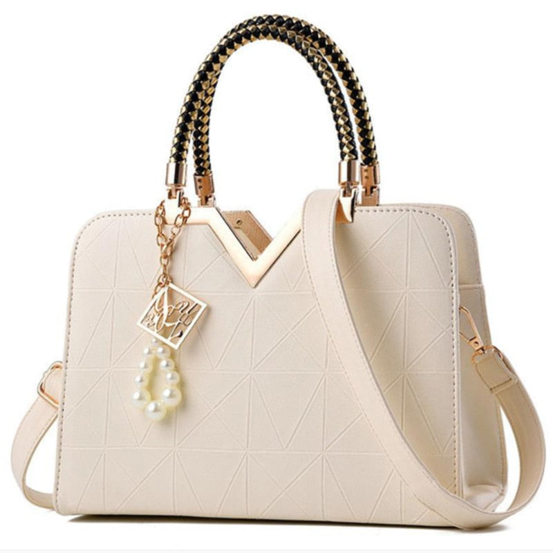 Elegant women's handbag in cream white color with gold accent top handle
