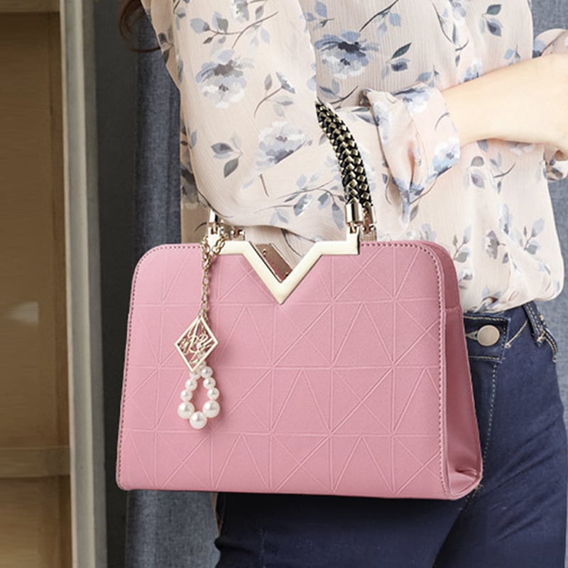 Elegant pink women's handbag with shoulder strap and gold handle detail
