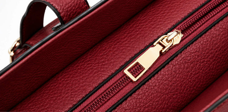 Close-up view of gold zipper hardware and textured leather on embossed rose handbag
