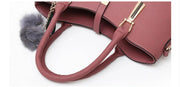 Close-up detail of pink handbag handles and premium textured leather finish