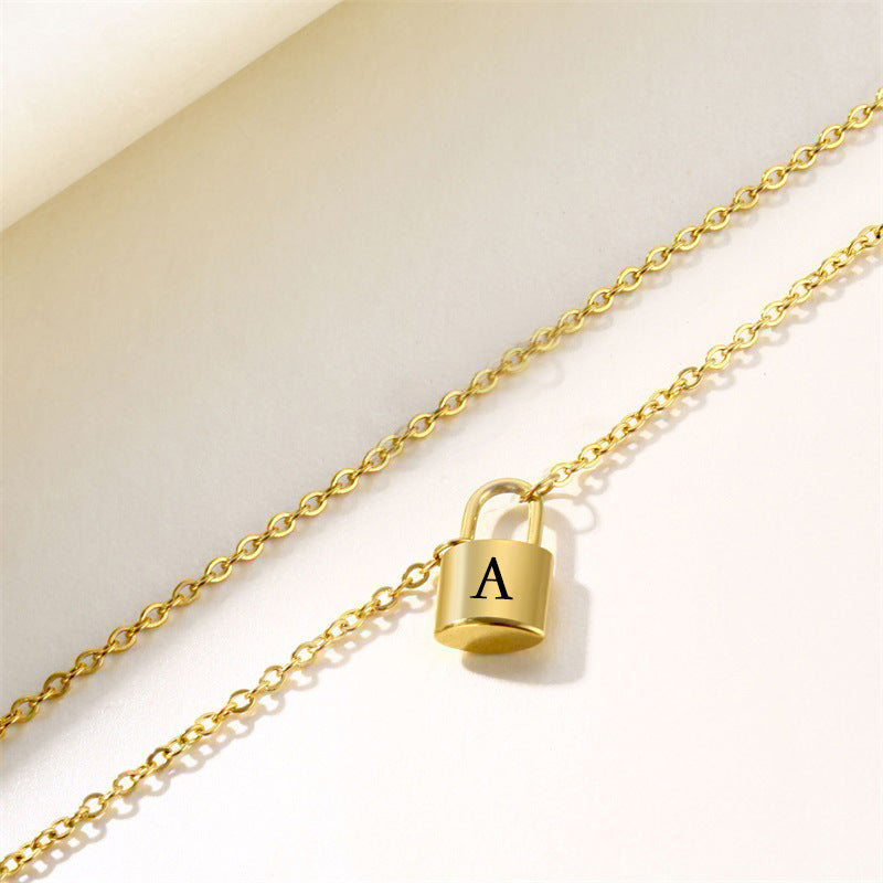 Gold iitial lock necklace with letter A pndant shown at an angle on soft background