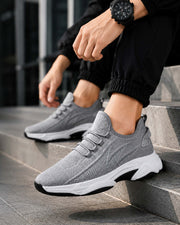 Man wearing gray height boost sneakers with breathable mesh design