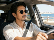 Man driving a car while wearing vintage round UV400 sunglasses for sun protection and comfort.
