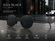 Vintage round sunglasses with black metal frame and full gray UV400 lenses on a modern urban background.
