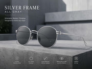 Vintage round sunglasses featuring a silver metal frame and gray UV400 lenses in a minimalist setting.
