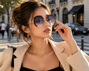 Elegant woman wearing black grey rimless oversized cut lens sunglasses on a luxury city street, premium fashion eyewear lifestyle portrait with modern urban style.
