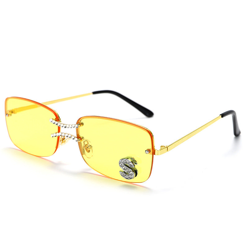 Yellow lens square rimless sunglasses with gold metal frame and crystal S accent on white background
