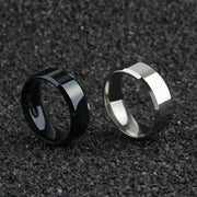 Black and silver minimalist men's band rings 8mm on textured surface.