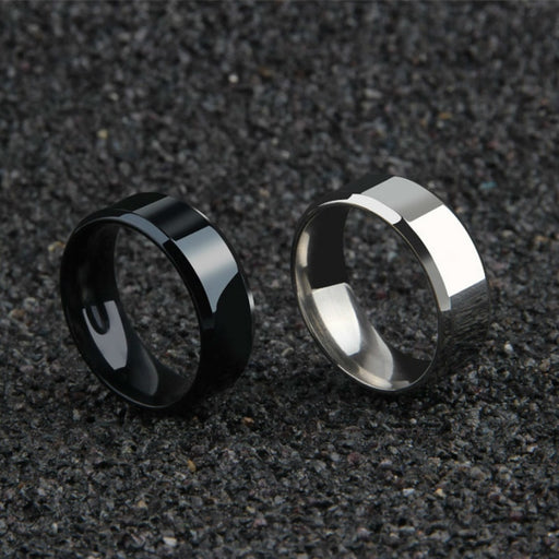 Black and silver minimalist men's band rings 8mm on textured surface.