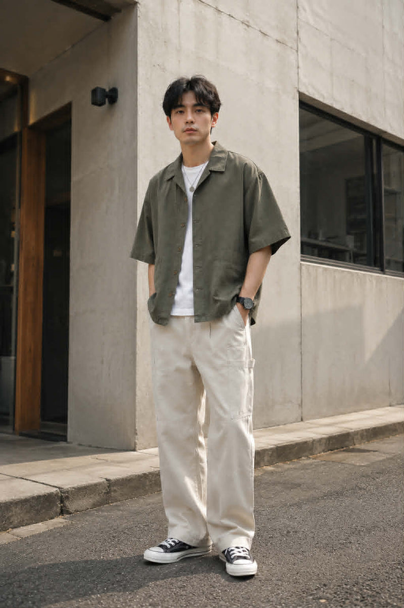 Men's oversized Japanese workwear Cuban collar shirt in army green featuring rounded patch pockets, styled with beige cargo pants for a relaxed streetwear look.

