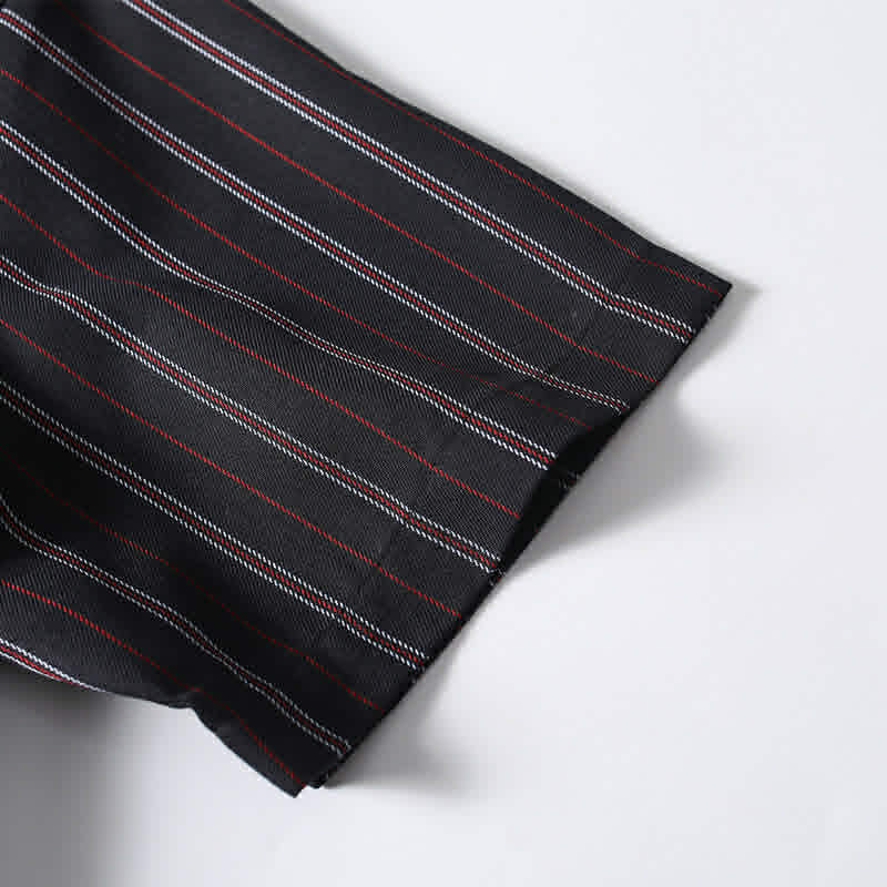 Short sleeve cuff detail of men’s black retro striped loose fit casual shirt showing quality craftsmanship.
