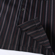 Close-up of the hem finish on a men’s black retro striped loose fit casual shirt with premium stitching and clean construction.
