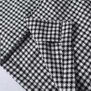 Close-up of hem stitching and fabric construction on men's black and white checkered shirt