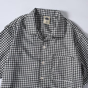 Close-up detail of men’s breathable checkered button-up Cuban collar shirt
