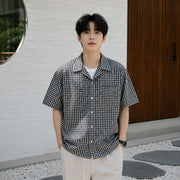 Men's black and white checkered Cuban collar short sleeve shirt styled for casual summer wear