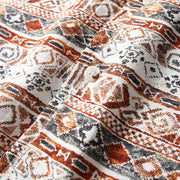 Close-up of shirt button and Hawaiian print fabric with geometric pattern.
