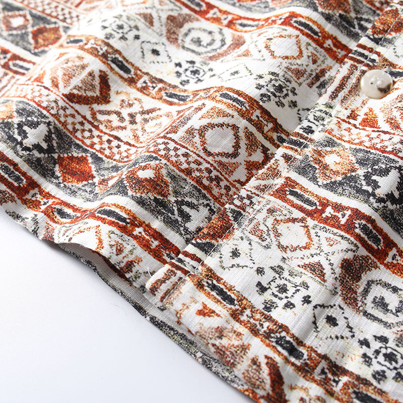 Bottom hem detail of Hawaiian print Cuban collar shirt showing stitching and fabric texture.
